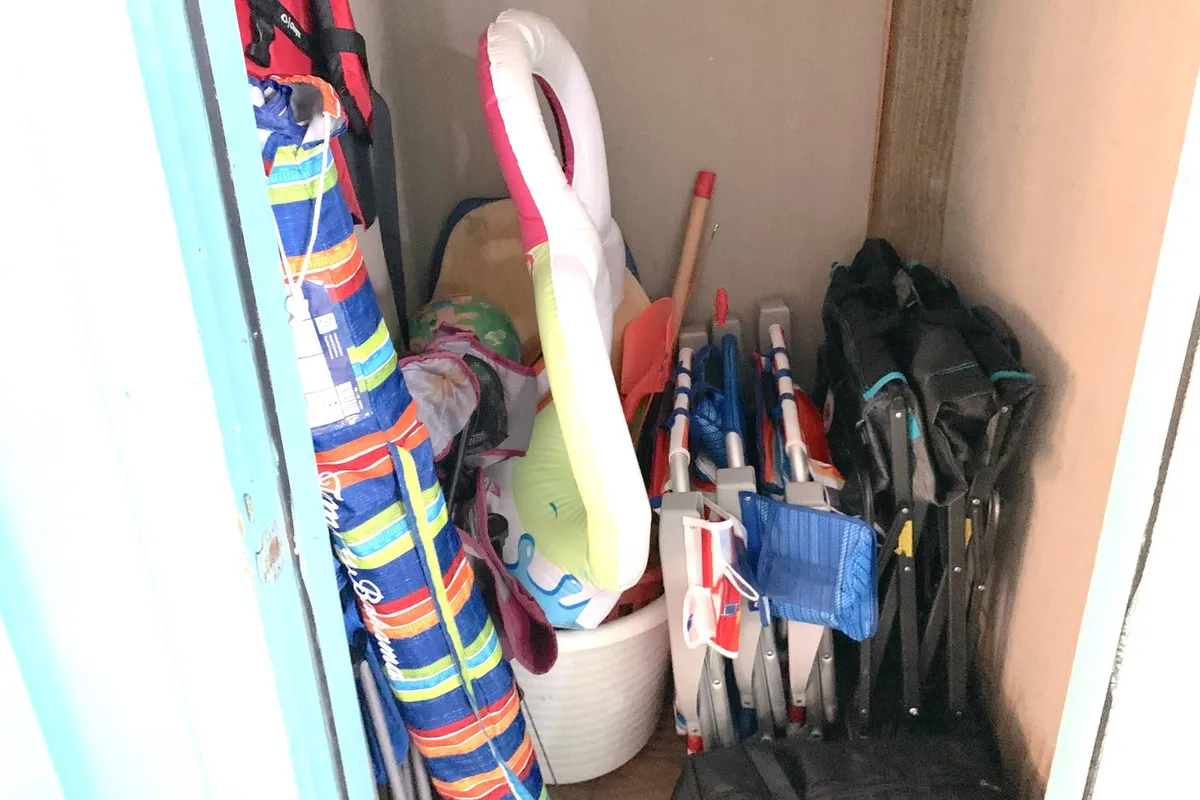 A bright, inviting corner with colorful pool floats, folding chairs, and a handy storage basket overflowing with beach and pool gear. The playful atmosphere suggests easy access to family-friendly amenities and fun-filled summer days.